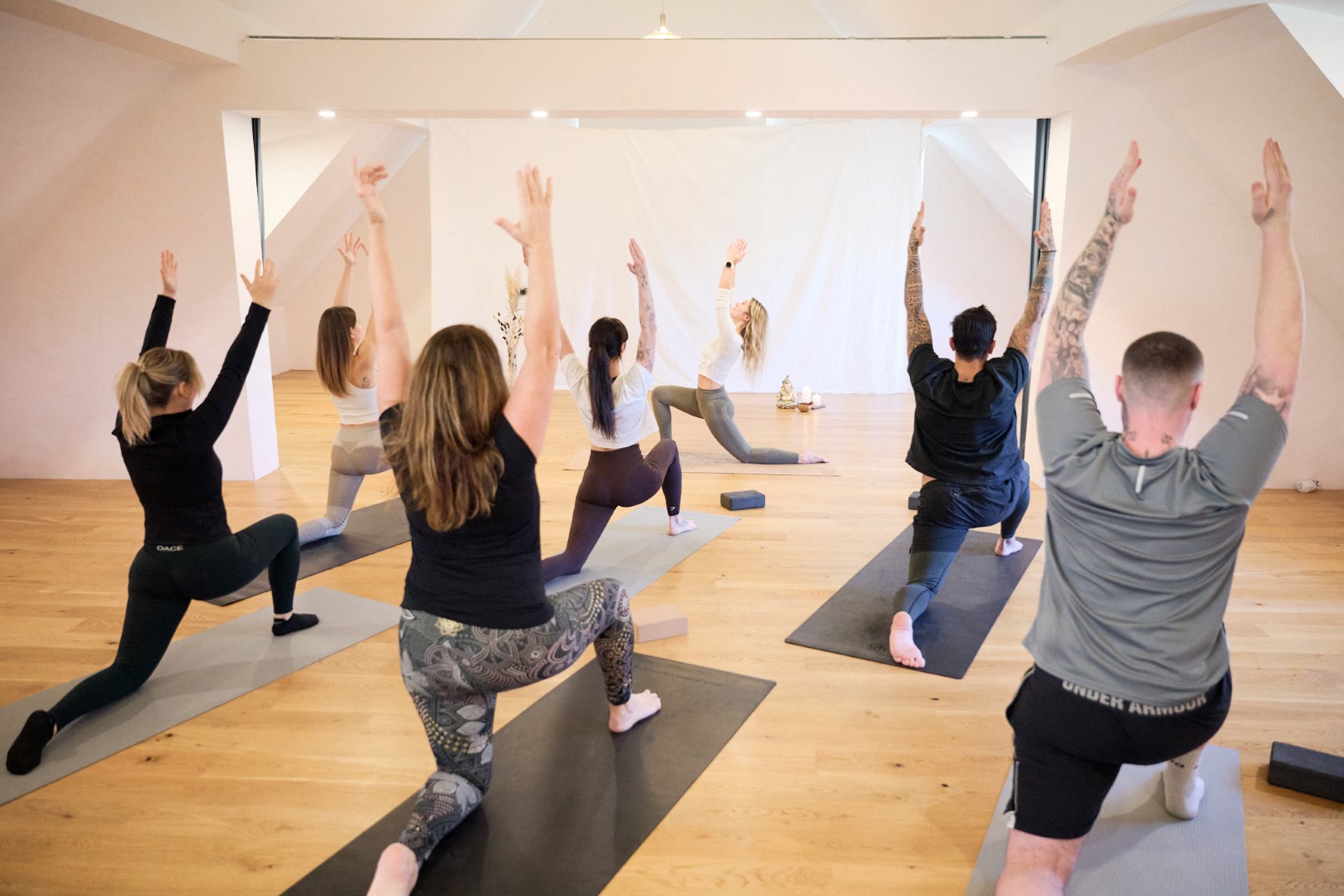 Gruppe von Menschen bei einer Yogaklasse für Sanften Flow und Vinyasa Flow-Yoga. Achtsame Bewegungen und entspannte Atmosphäre